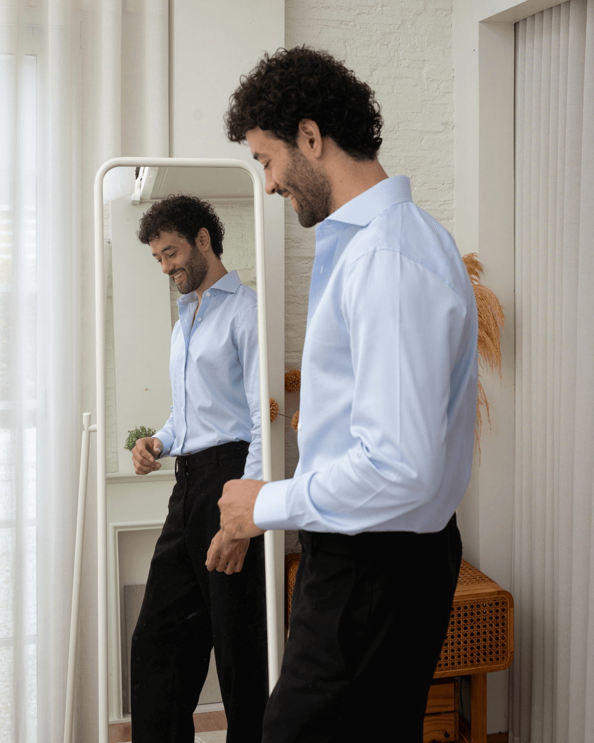 man wearing stripe blue shirt in front of a mirror